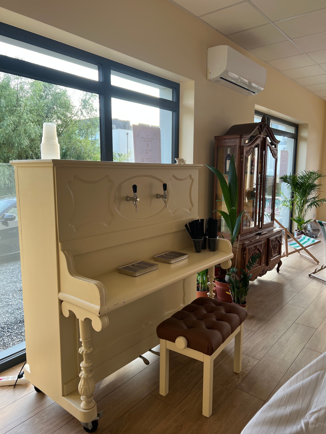 Pianino przerobione na bar z dwoma kranami i palmą